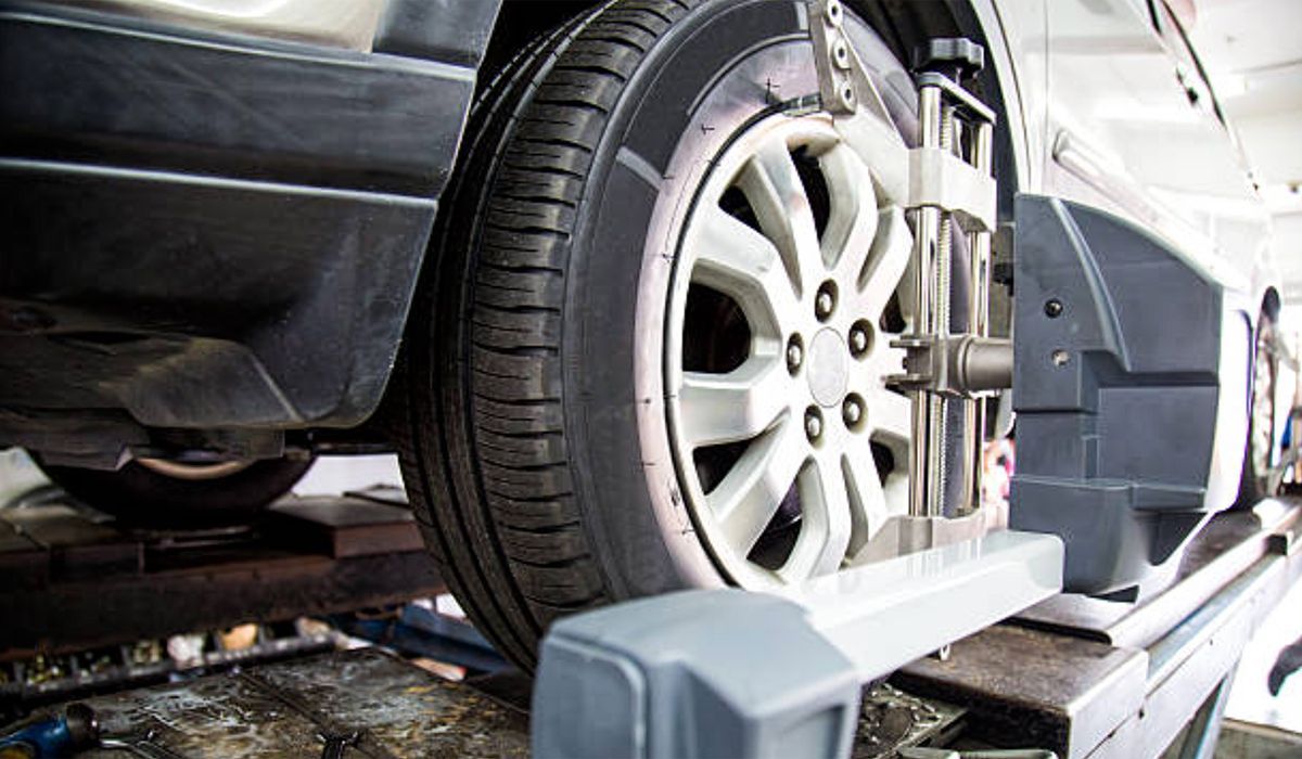 A car is being aligned on a machine in a garage.