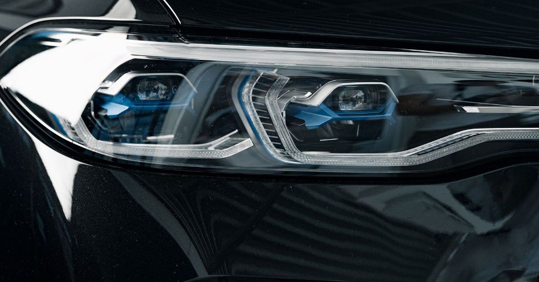 A close up of the headlight of a black car