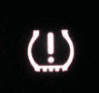 A tire warning sign is lit up in the dark