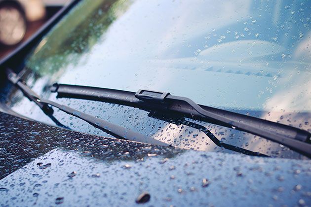 A close up of a car windshield with water drops on it.