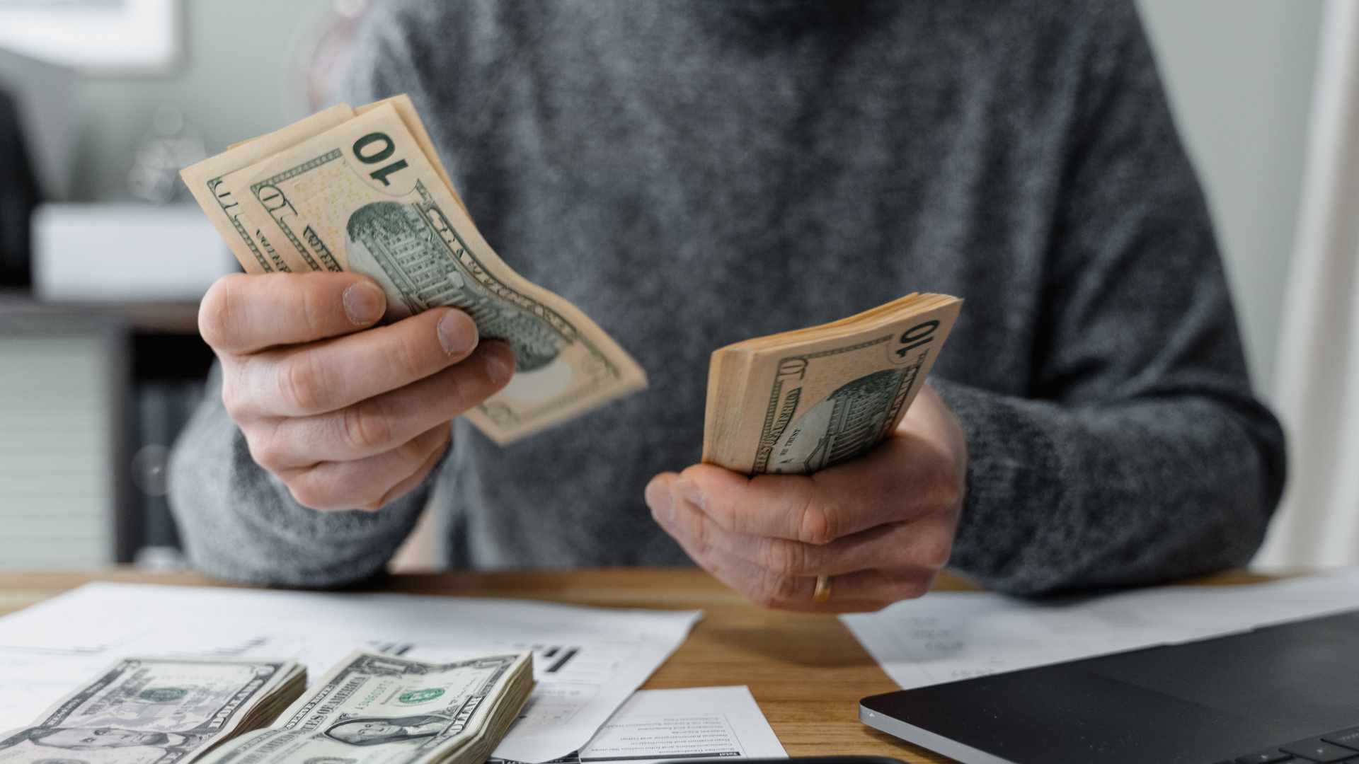 A woman is holding a 100 dollar bill in her hands.