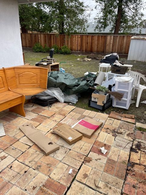 There is a lot of trash on the ground in the backyard.
