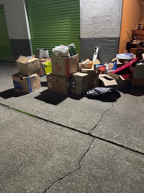A bunch of boxes are stacked on top of each other on the sidewalk.