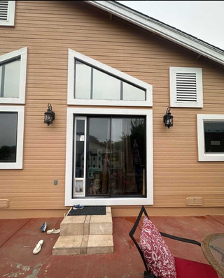 A house with a sliding glass door and many windows