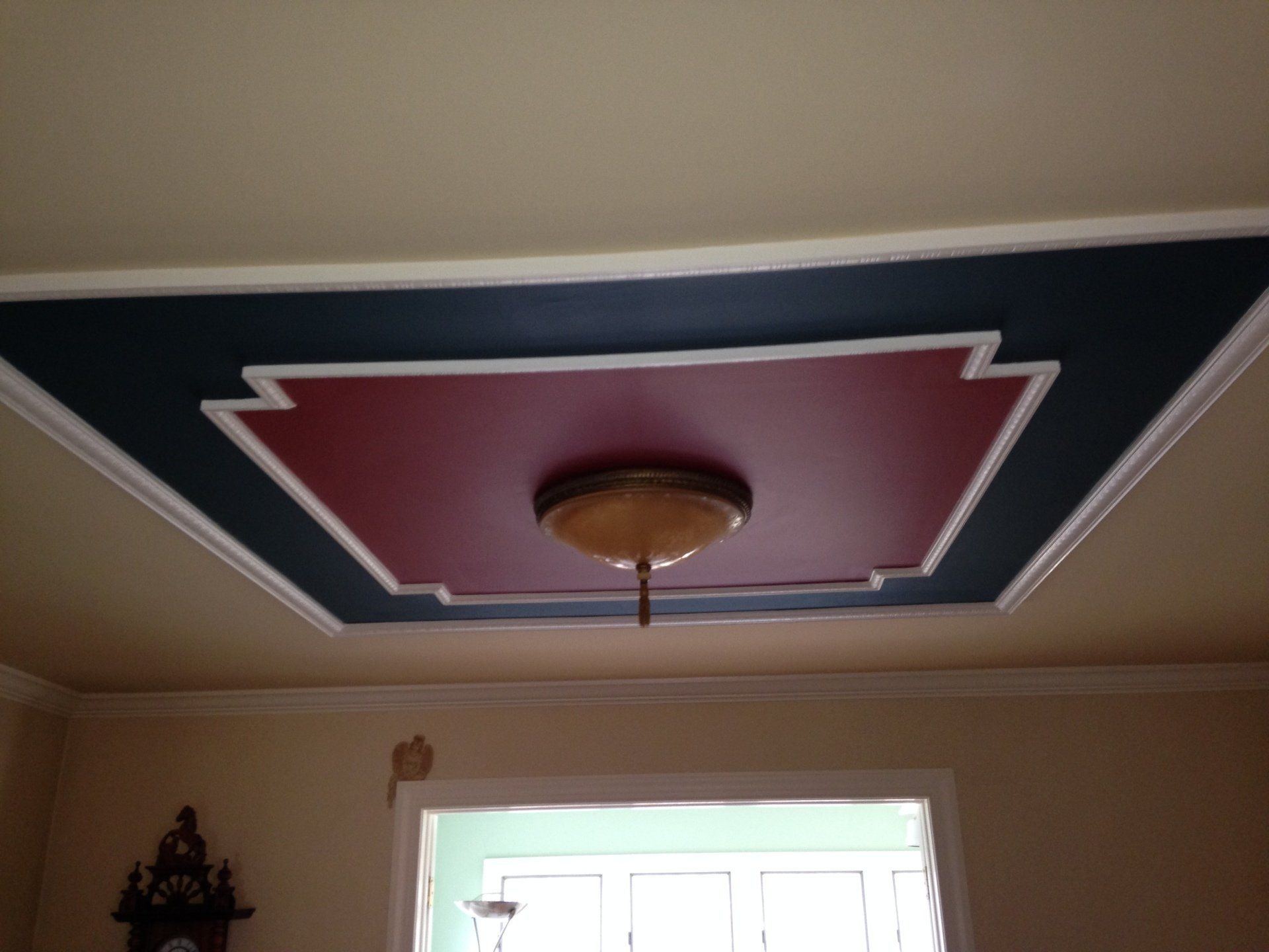 A red and blue ceiling with a clock in the background