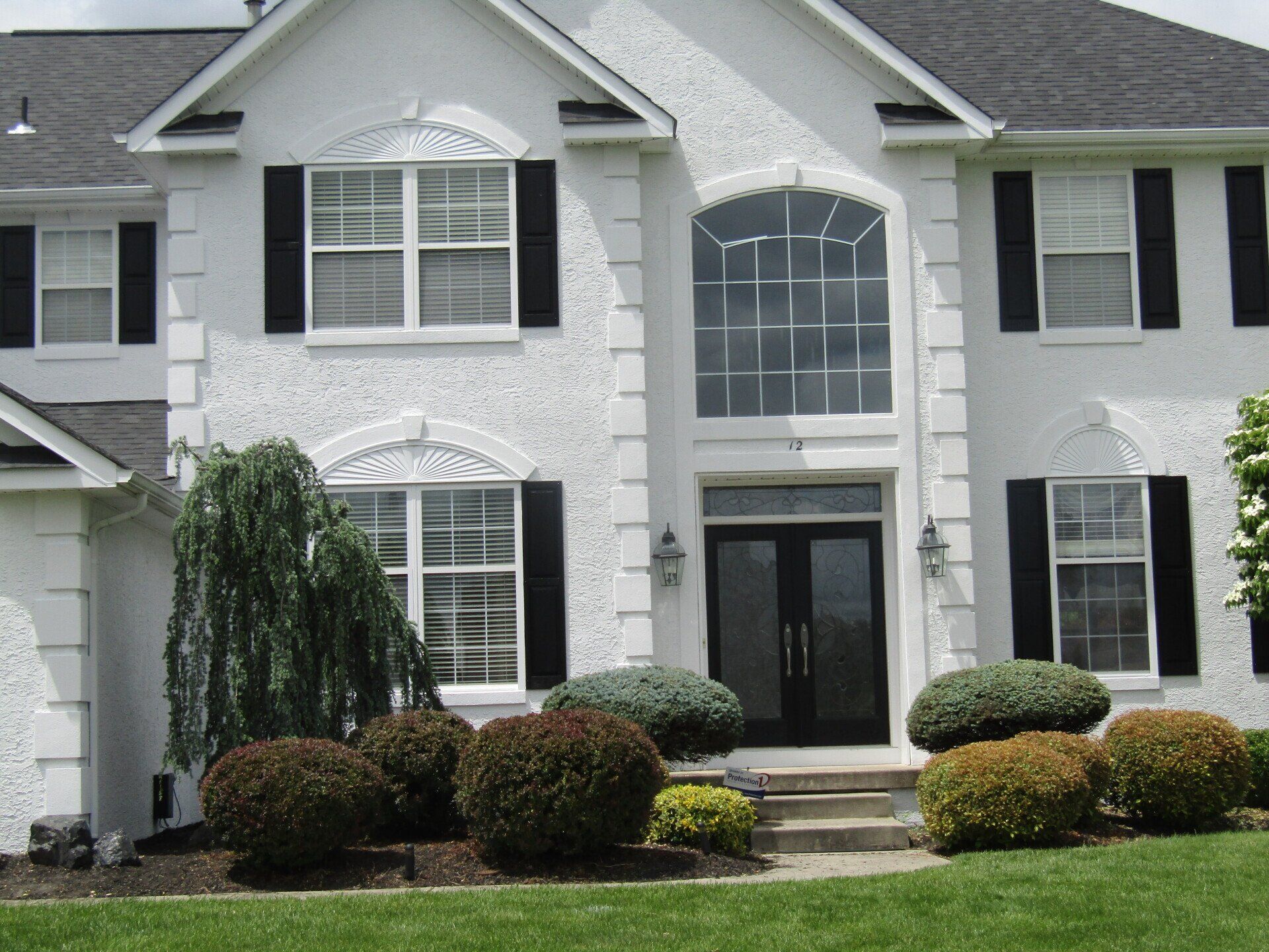 A large white house with black shutters on the windows