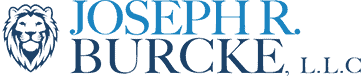 Logo for Joseph R. Burcke, L.L.C., featuring a lion's head, and blue lettering.
