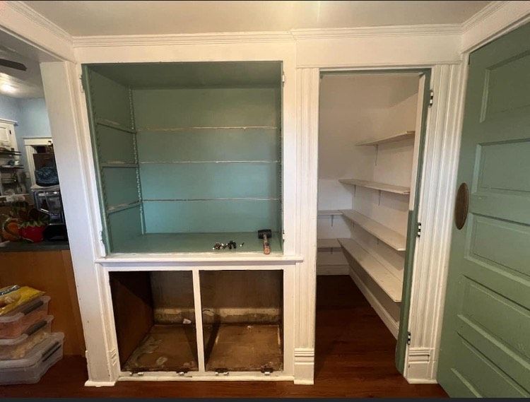 A closet with shelves and a green door