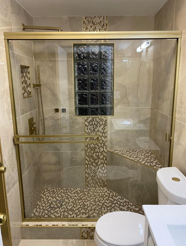A bathroom with a sliding glass shower door and a toilet.