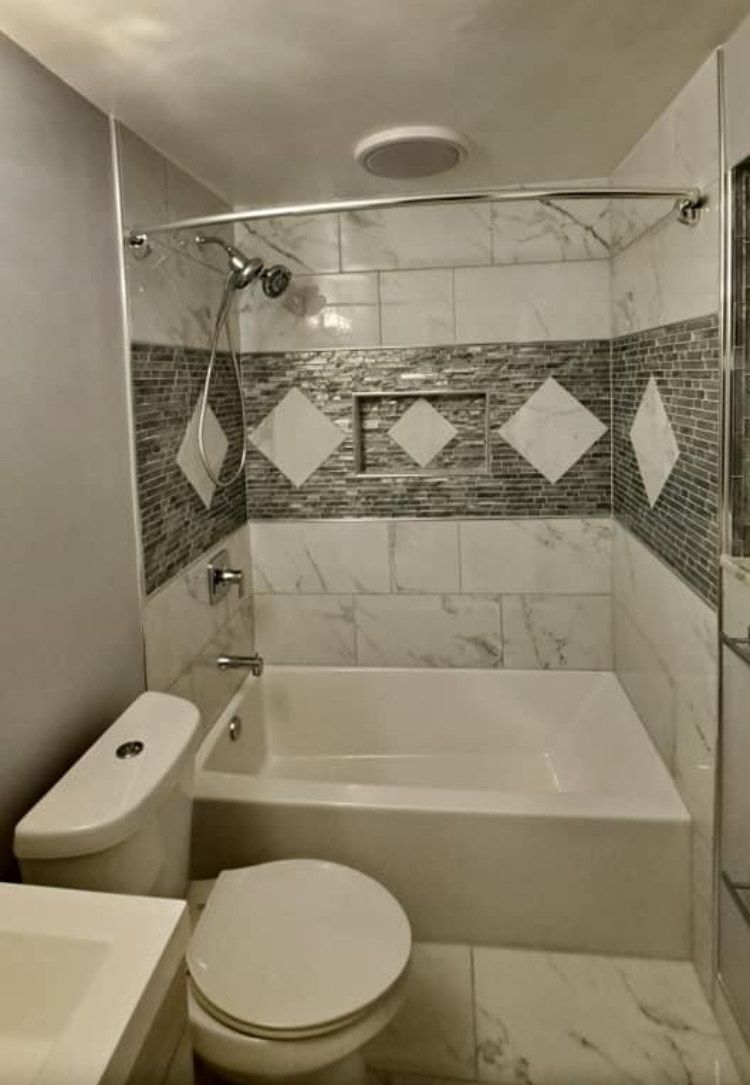A bathroom with a toilet , sink , bathtub and shower.