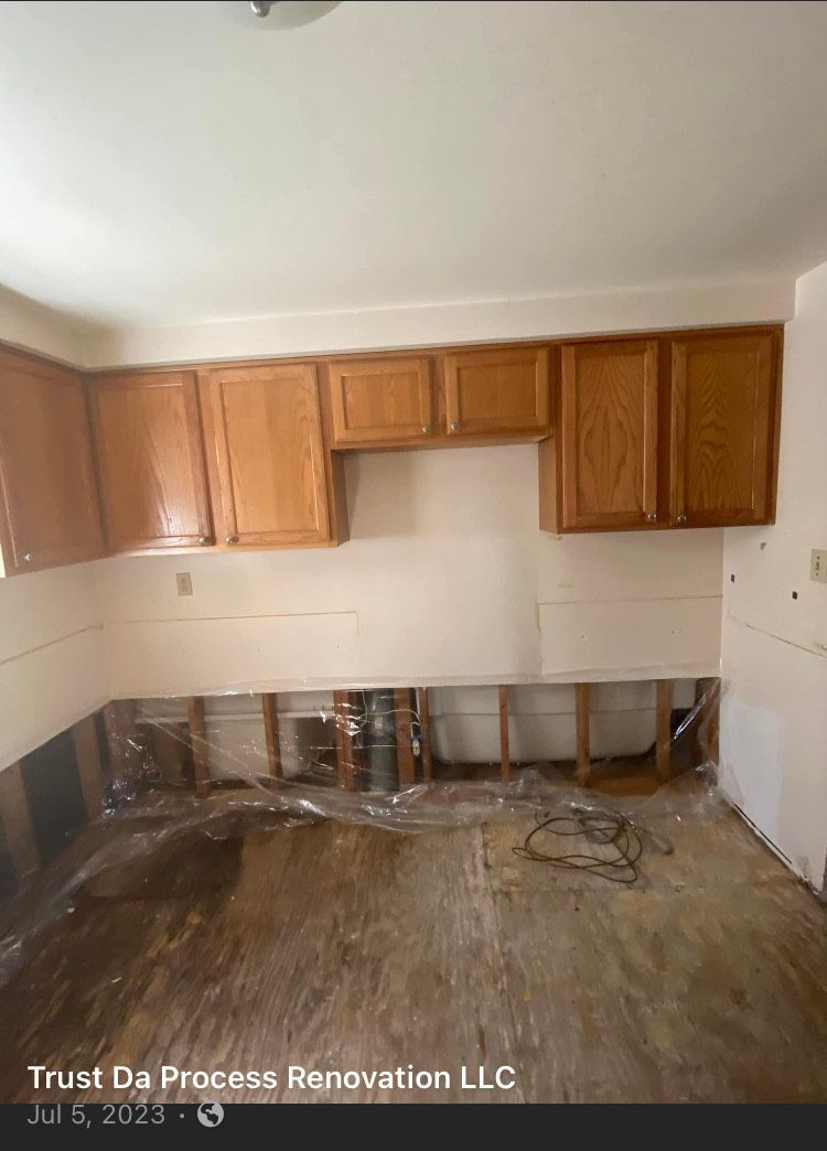 A kitchen with wooden cabinets and white tiles is being remodeled.