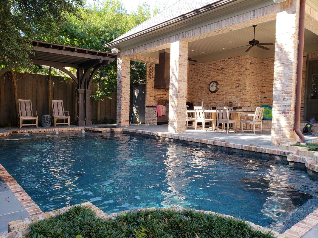 There is a large swimming pool in the backyard of a house.