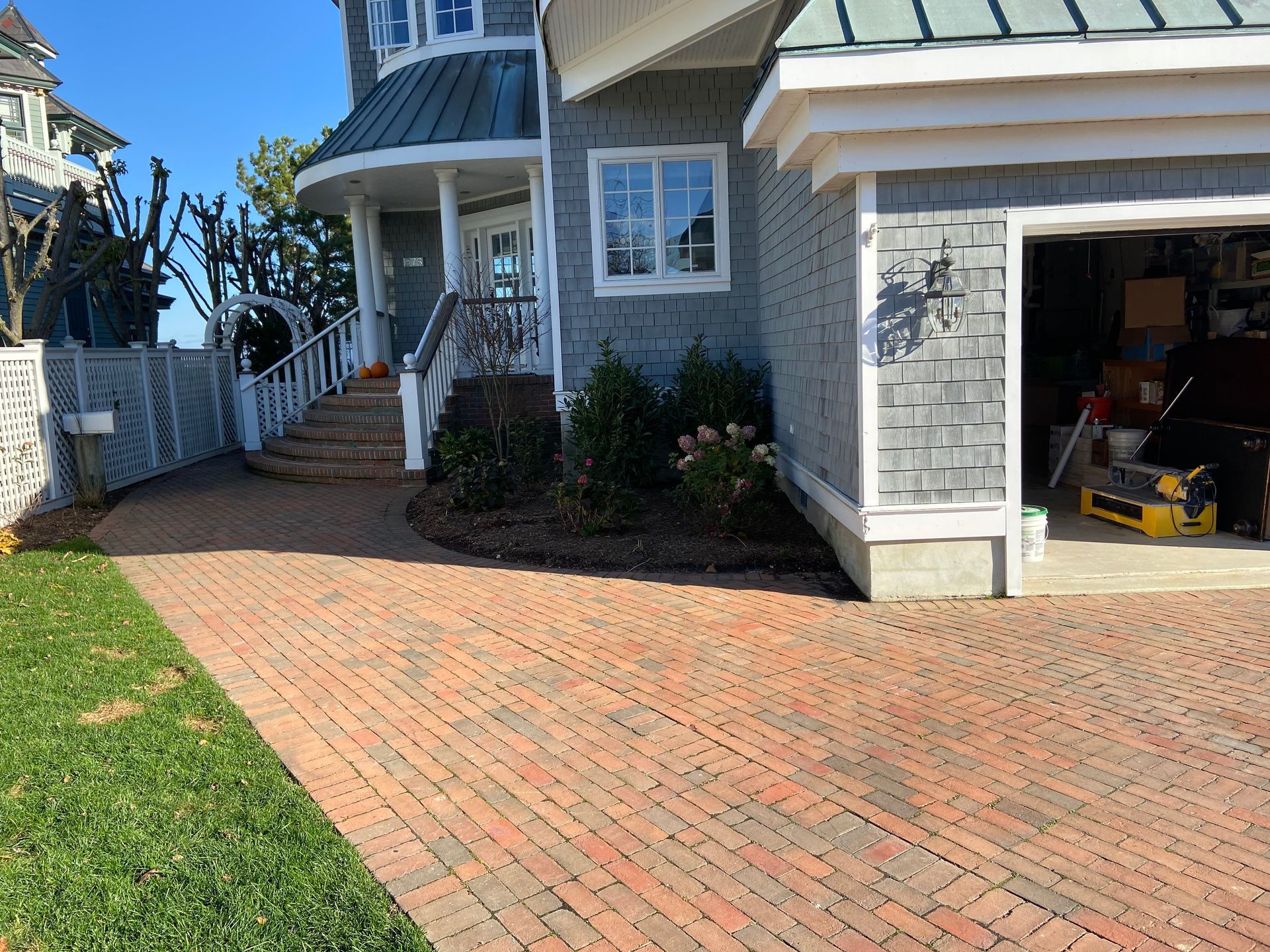 A large house with a brick driveway leading to it and a garage.