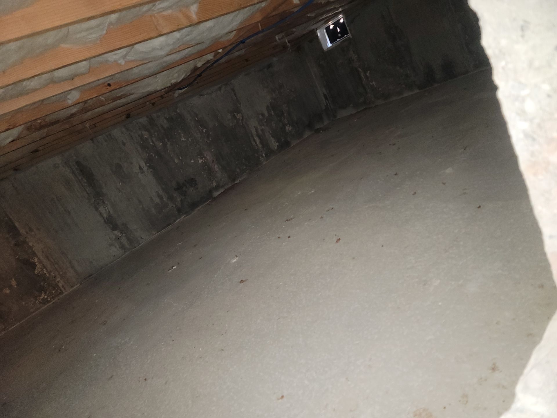 A very dark room with a ceiling fan in the corner.