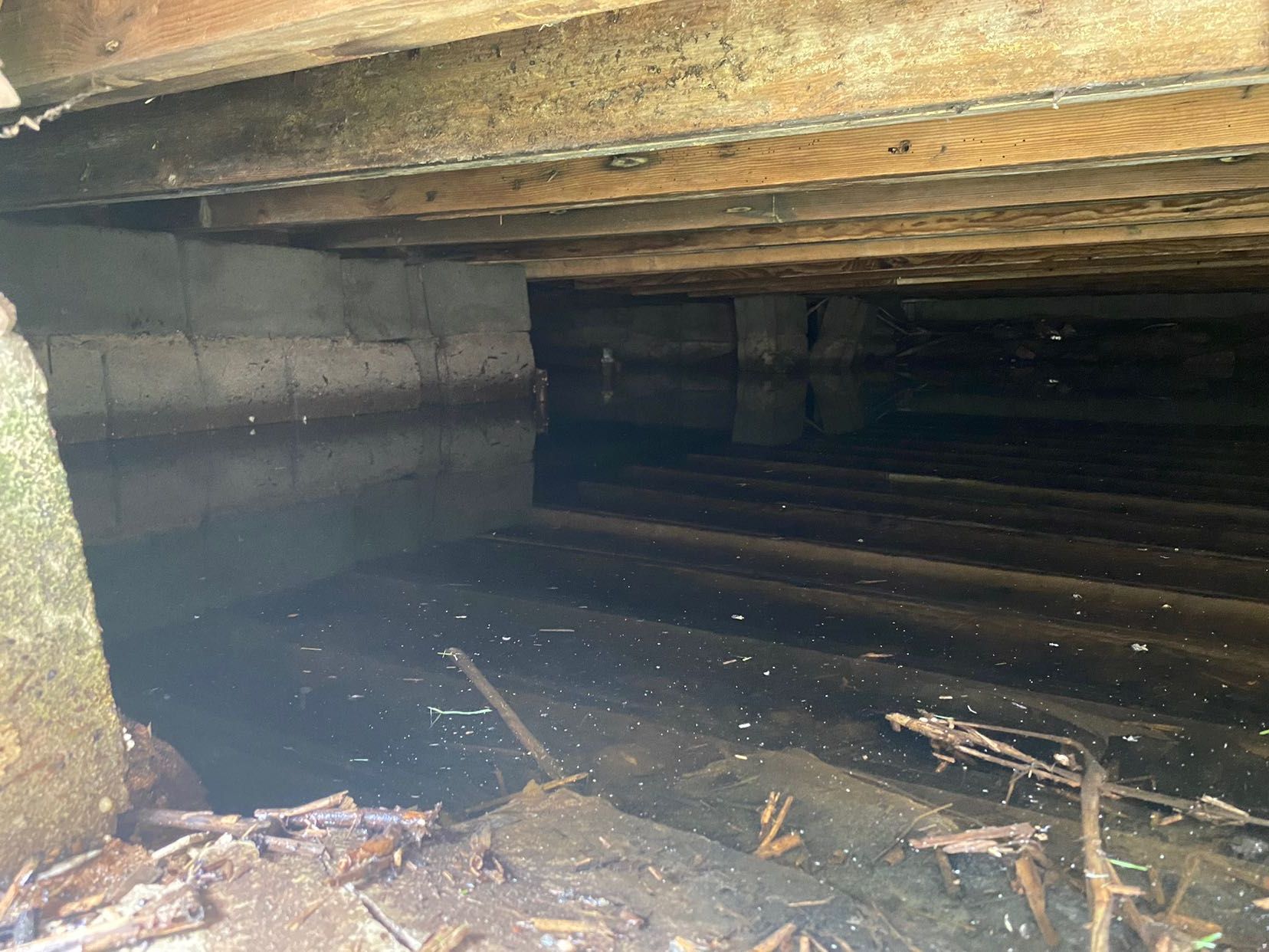 A dark basement with a lot of water coming out of it.