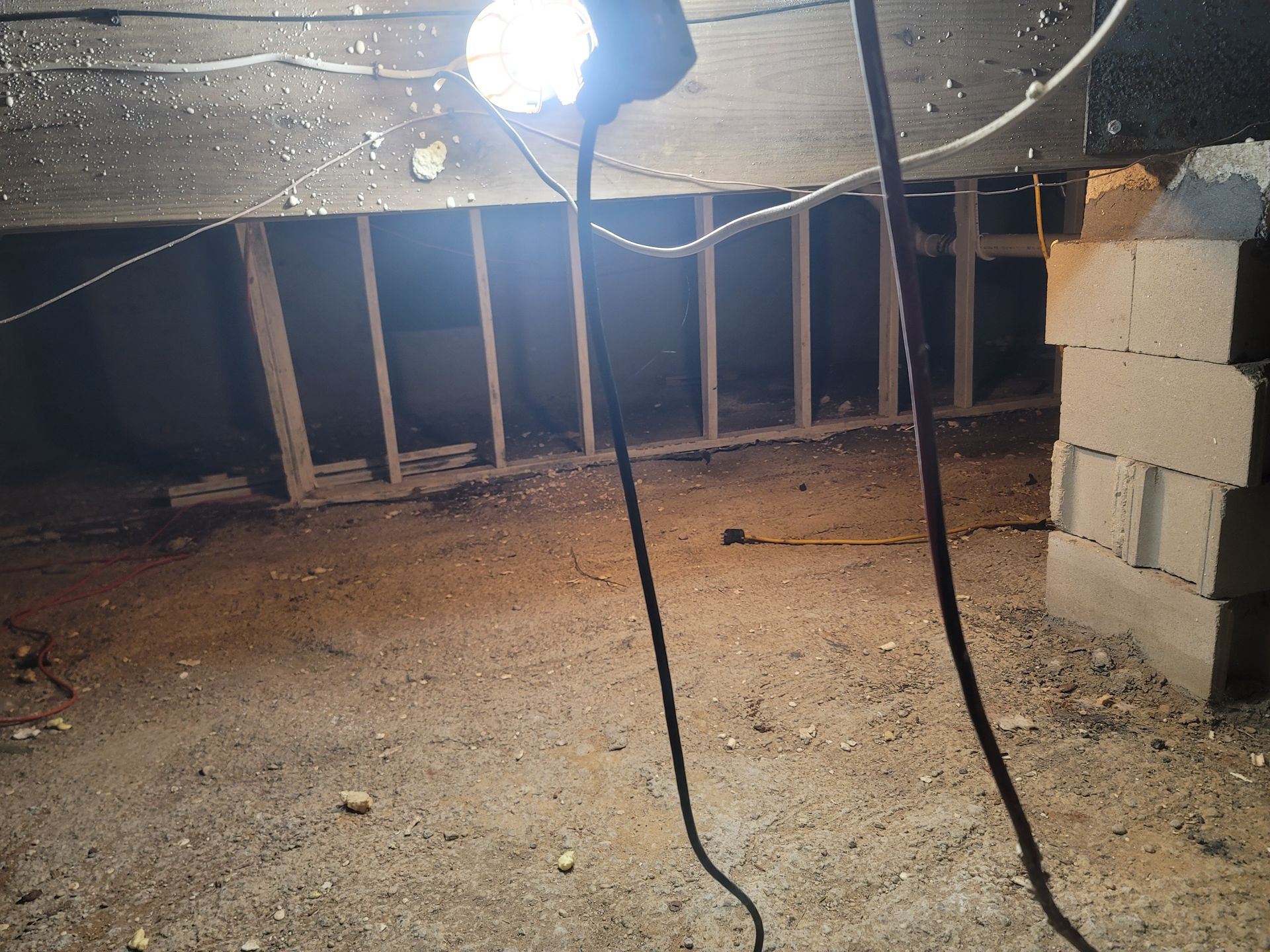 A light is hanging from the ceiling of an attic.