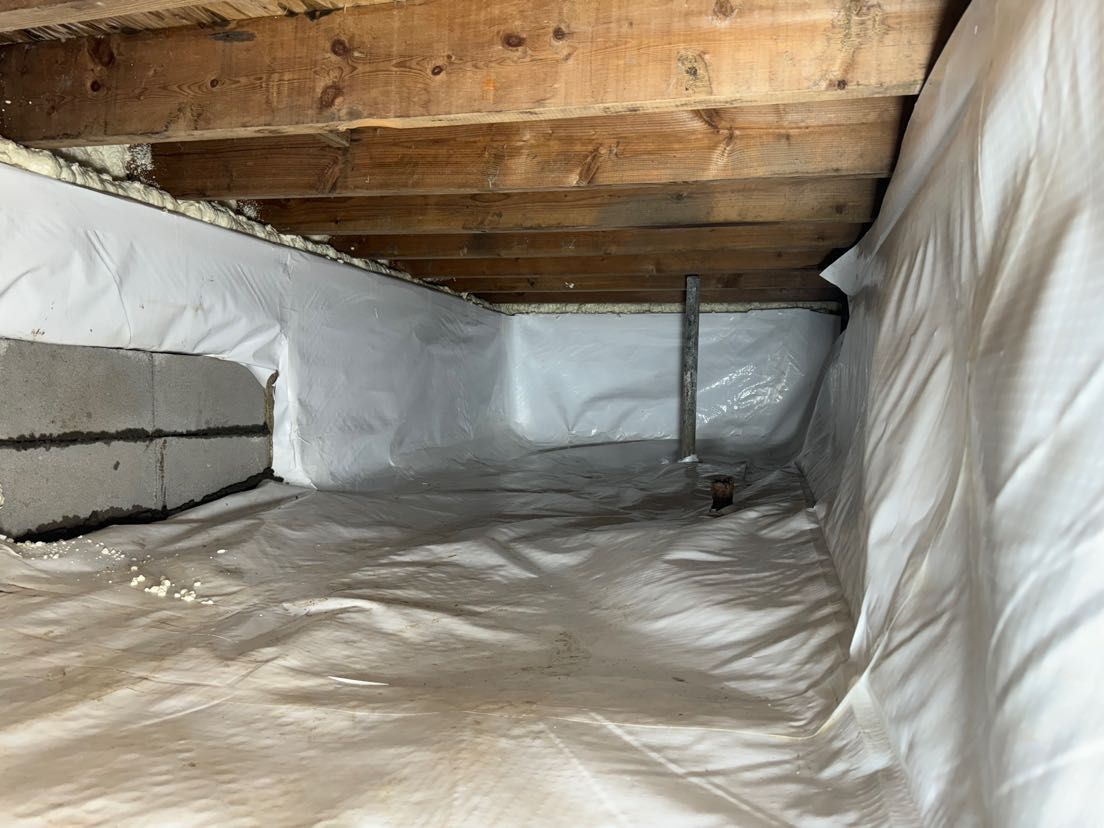 A crawl space under a house with a lot of insulation.
