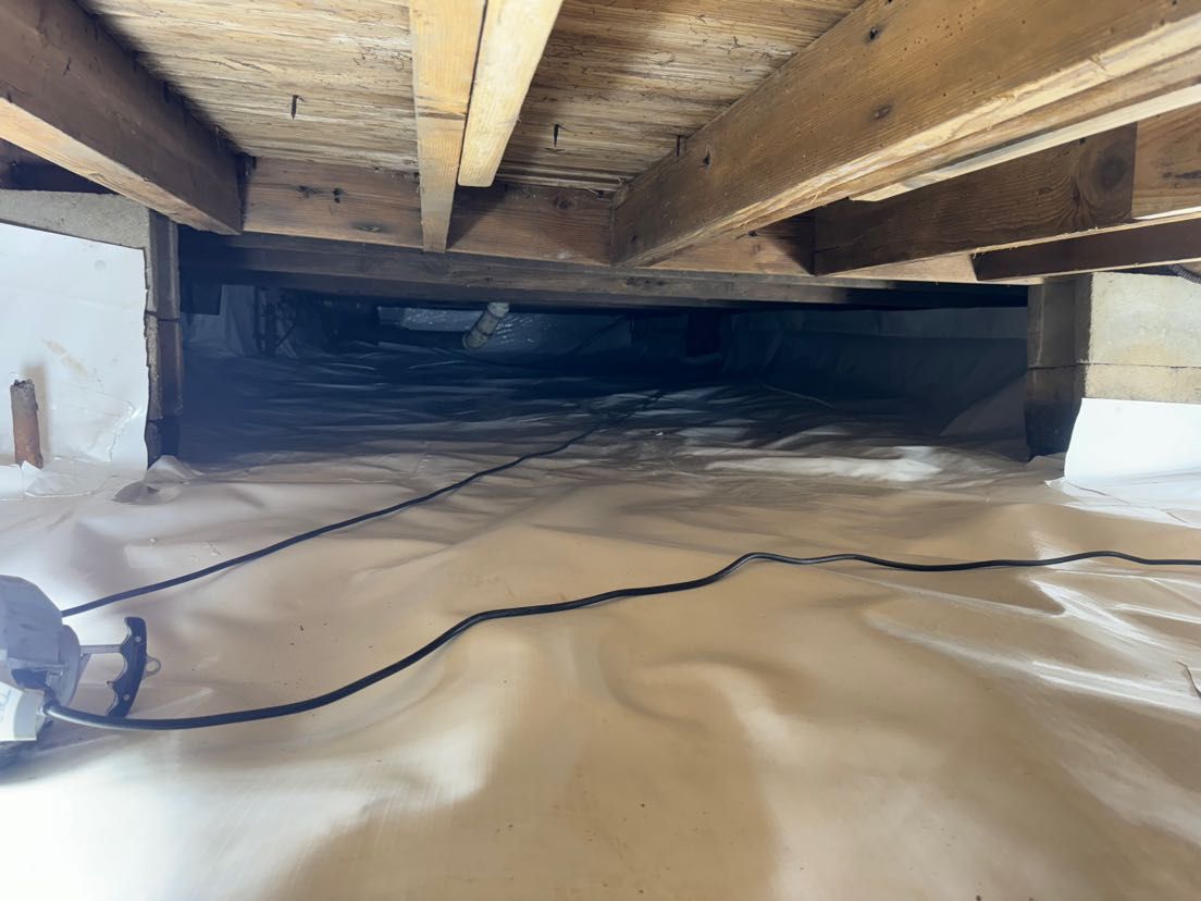 A crawl space under a house with a lot of wires coming out of it.