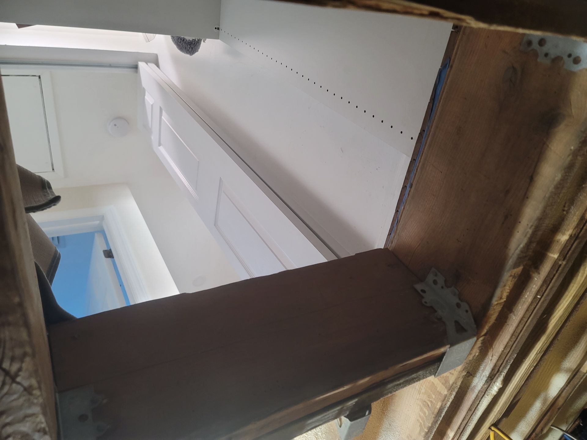 A person is working on a cabinet in a kitchen.