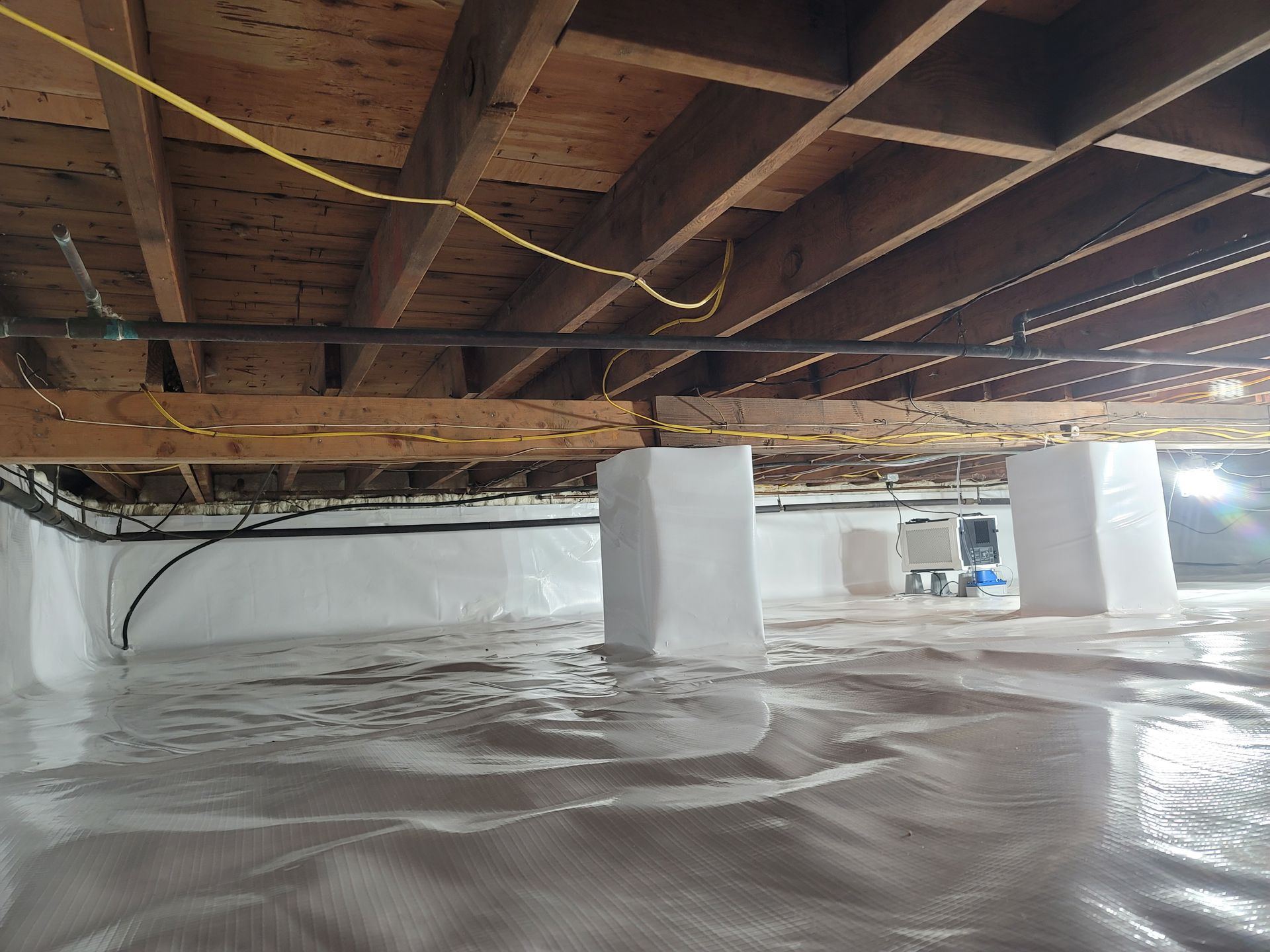 A basement with a lot of wires hanging from the ceiling.
