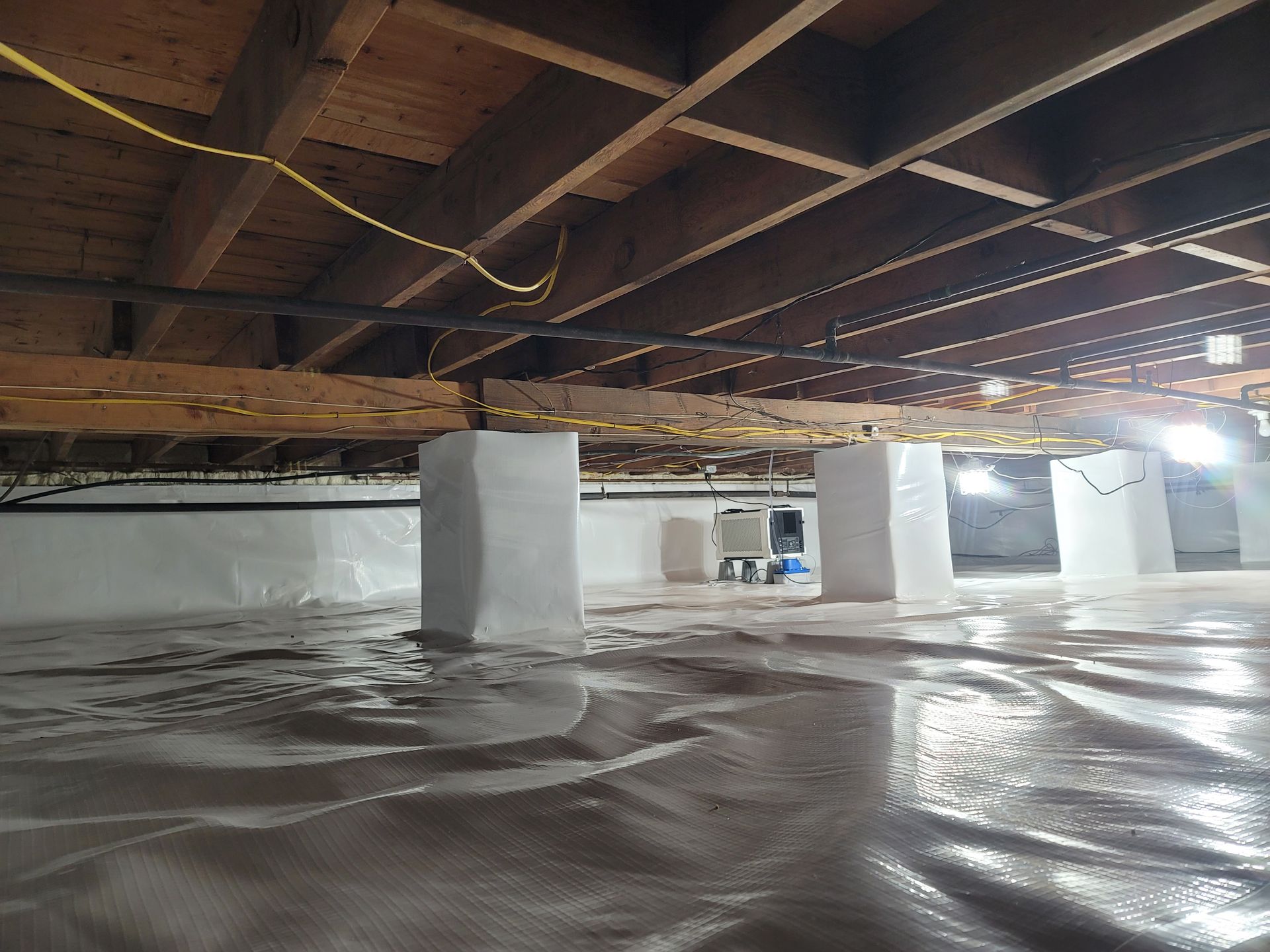 A basement with a lot of wooden beams and a lot of insulation.