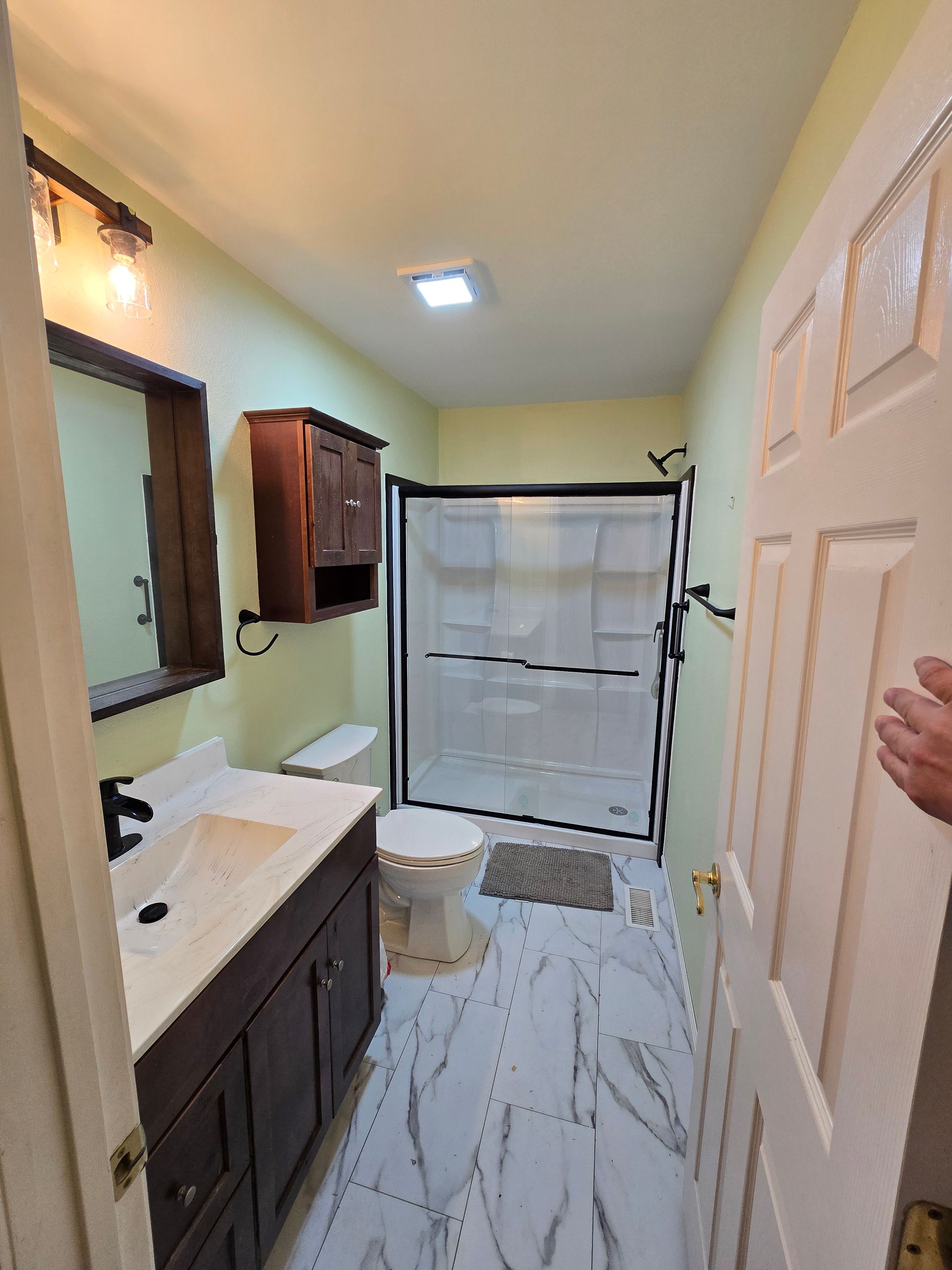 Small bathroom with vanity, mirror, shower curtain, and white tiled floor.