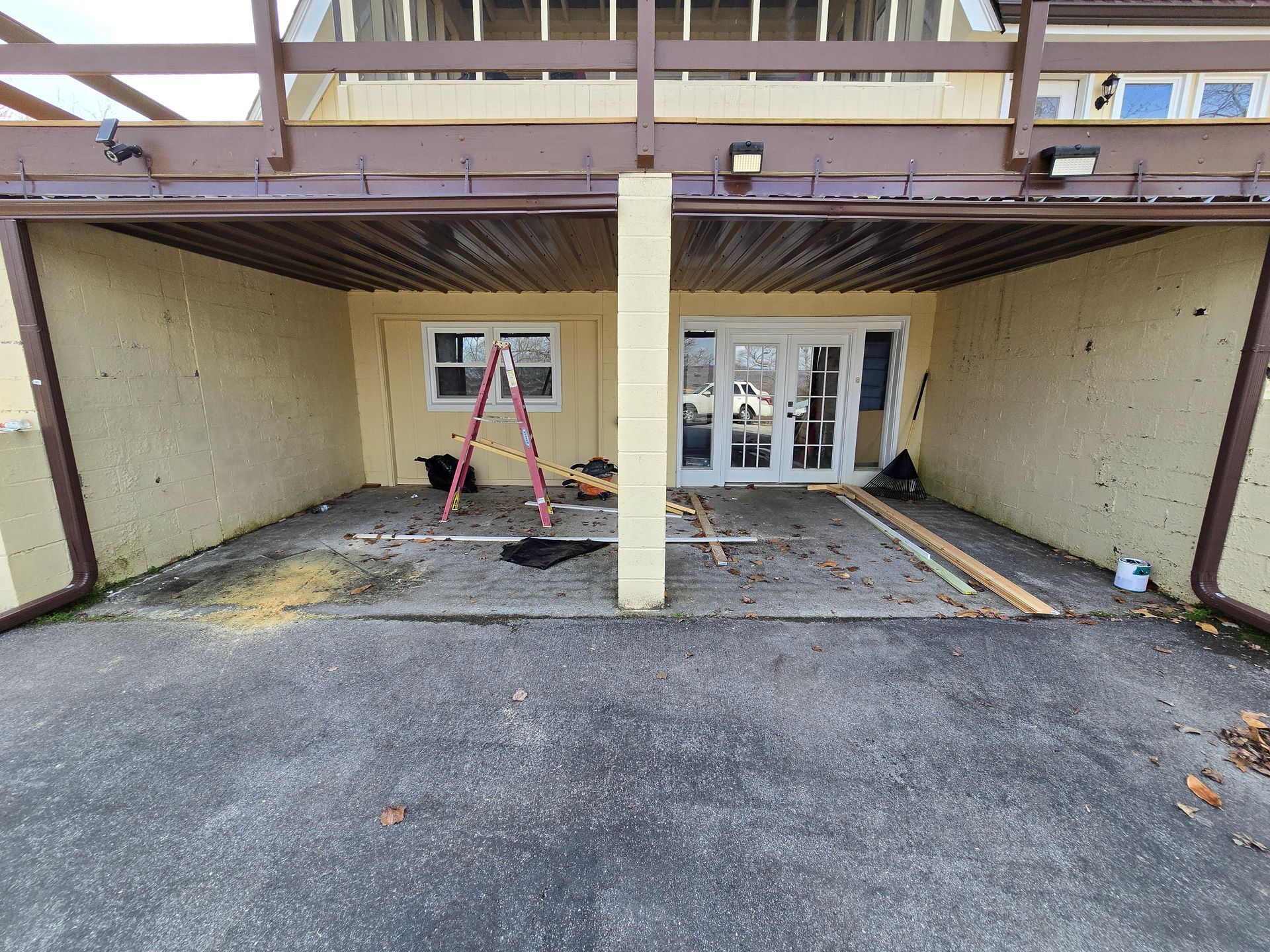 Accessible building entrance with a central pillar, ramp, and double doors under a covered overhang