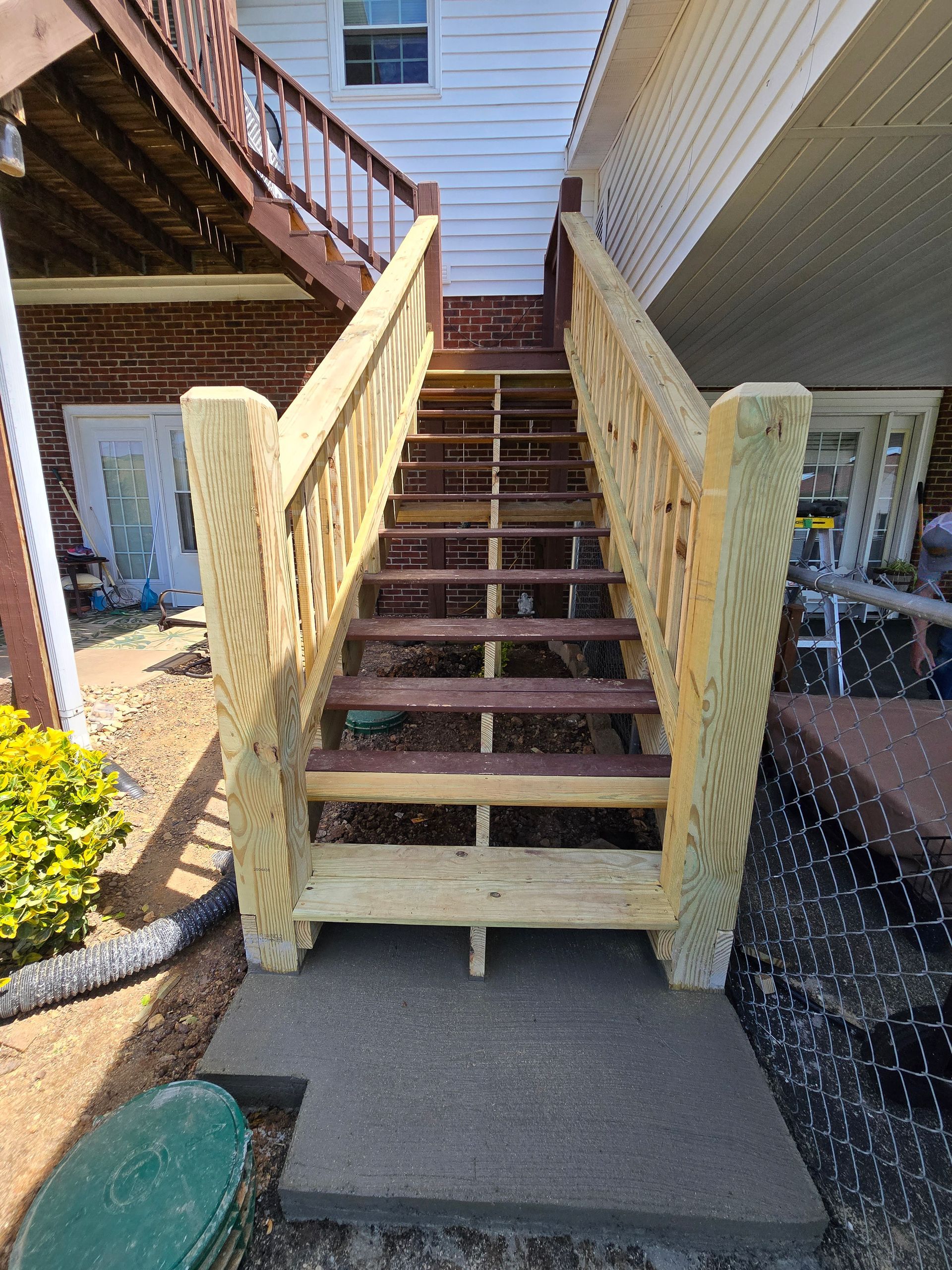 Front porch stairs with yellow railings and worn wooden steps leading up to a house entrance