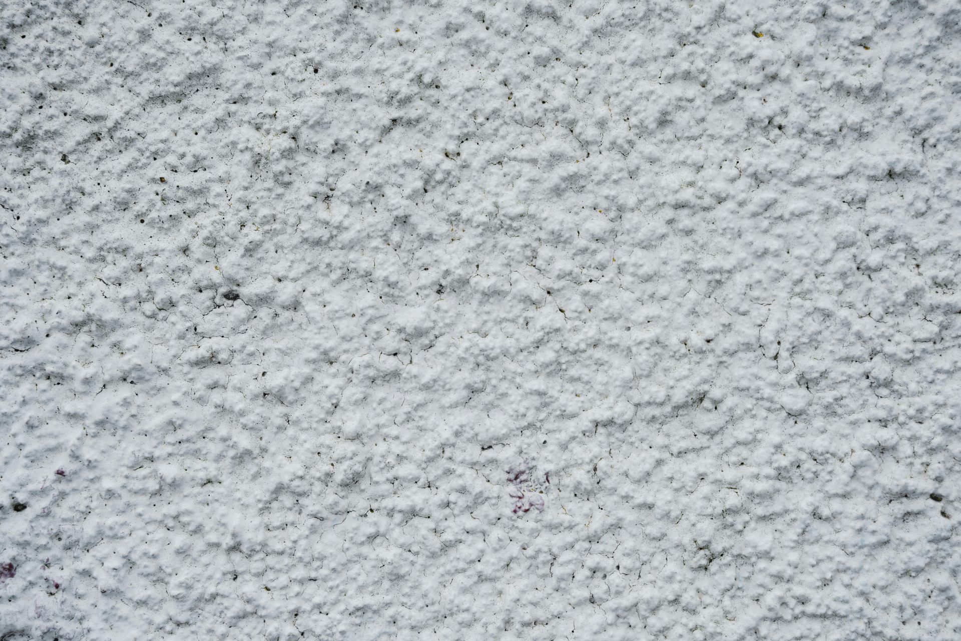 Close-up of a light gray rough-textured stucco wall
