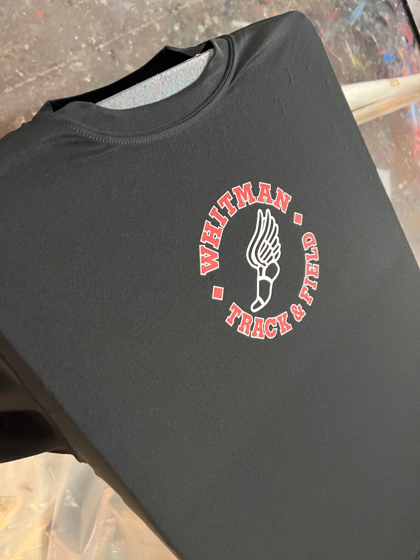 Black t-shirt with a custom silk screened red and white logo for 