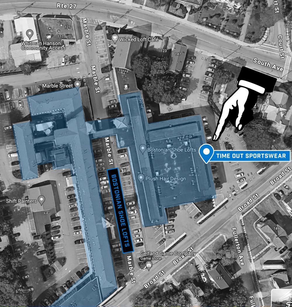 An overhead map view showing a building complex highlighted in blue with a white hand icon pointing toward the parking lot.