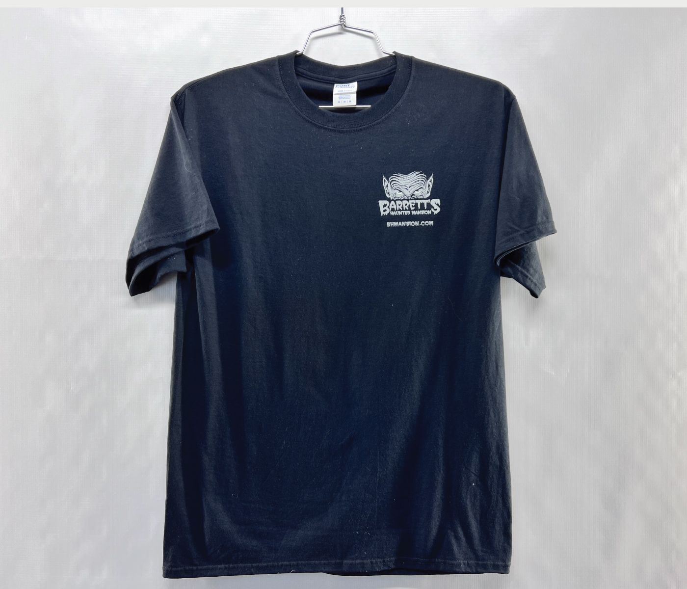 Dark blue t-shirt with a custom silk screened white logo on the chest, hanging on a metal hanger.
