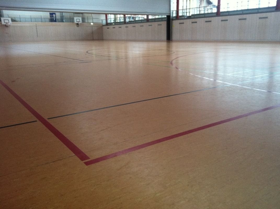 An empty basketball court with a red line on the floor, on a Hart's Athletic installed floor.