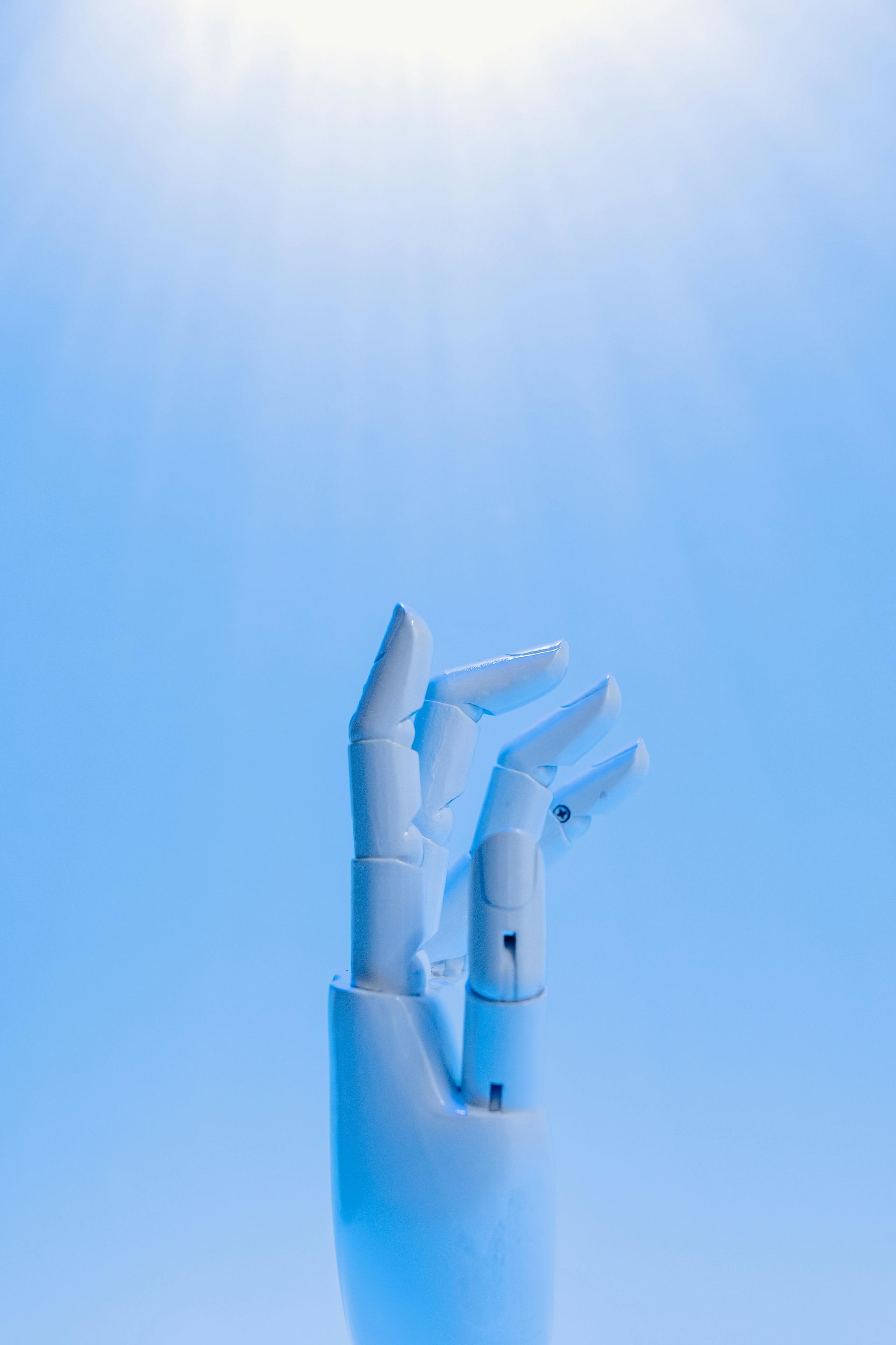 A close up of a robotic hand on a blue background.