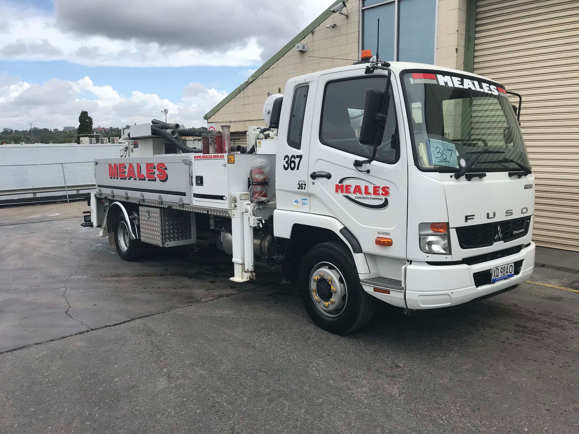 A white truck is parked in front of a building.