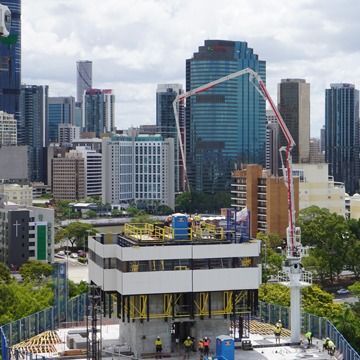 A building under construction with a city skyline in the background