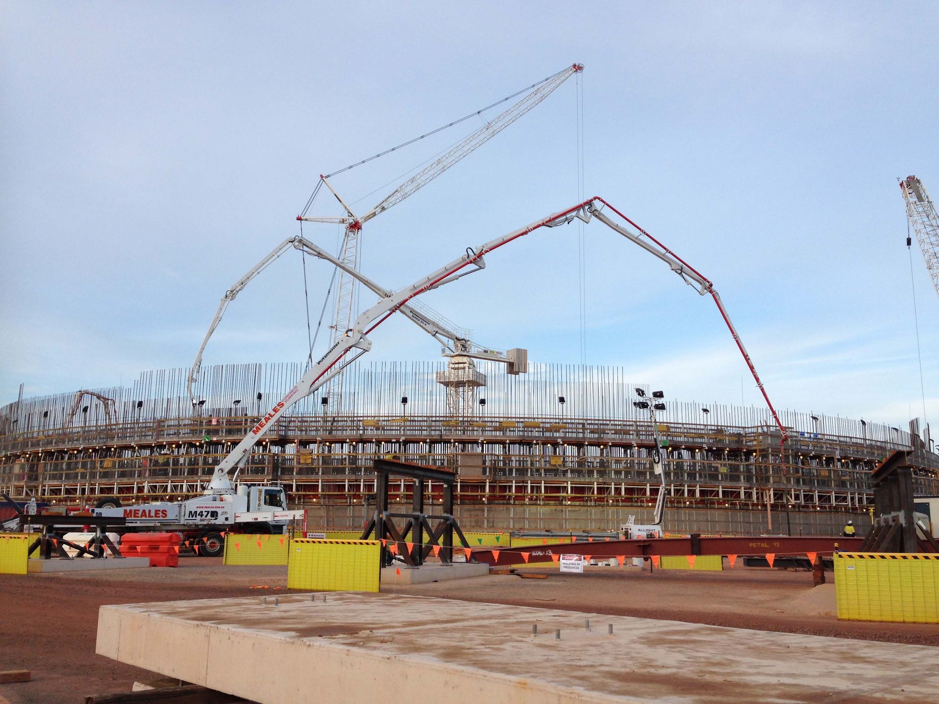 A construction site with a lot of cranes and concrete pumps