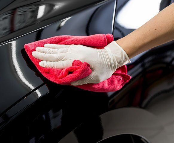 Worker Cleaning the Black Car — Erie, PA — Sparkle Clean Car Care