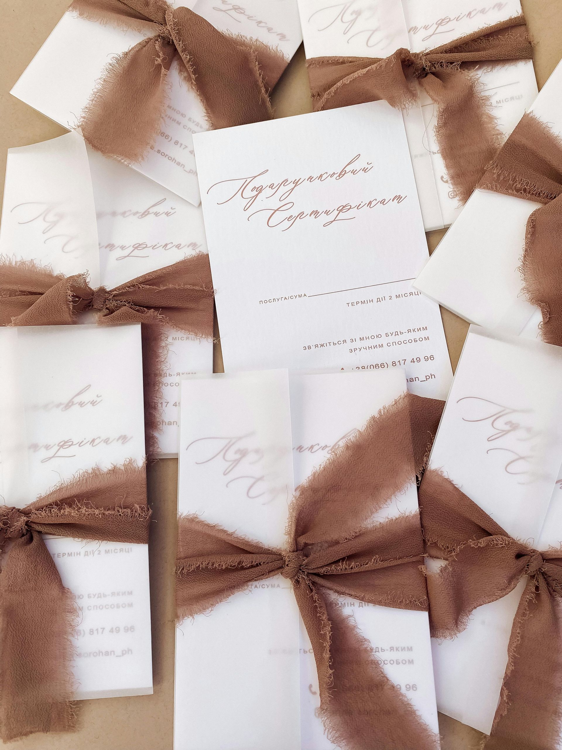 White cards with brown ribbon tied in a bow. Calligraphy script is visible.