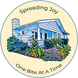 Blue Cottage Bakery logo or of a white house with flowers, reading “Spreading Joy One Bite At A Time”