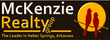 McKenzie Realty logo: two red birds on a branch in front of a yellow circle, text on a dark brown background.
