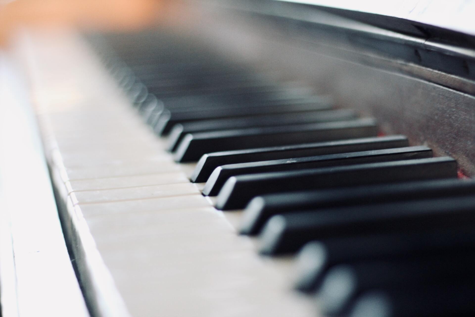 A close up of a piano keyboard with the keys visible