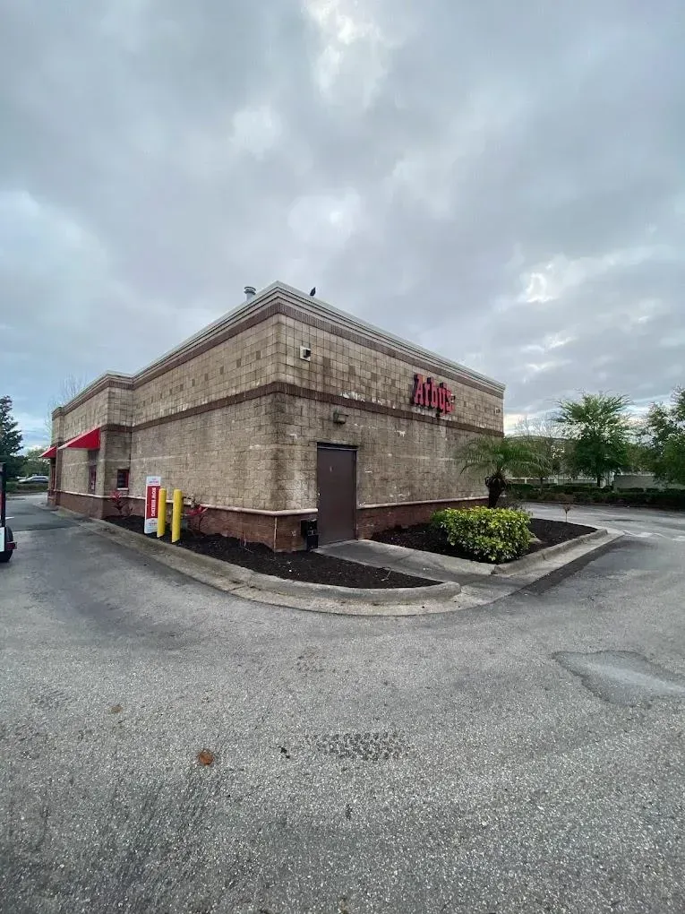 A tan brick building with red accents, labeled 