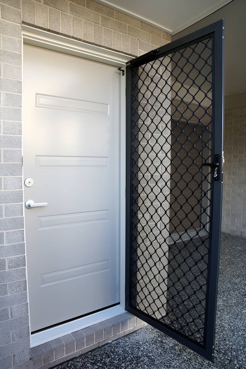 A White Door With a Black Screen on the Side of It — Manning Blinds & Awnings in Forster, NSW