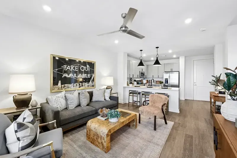 A stylish living room with a sofa, coffee table, and open-concept kitchen.