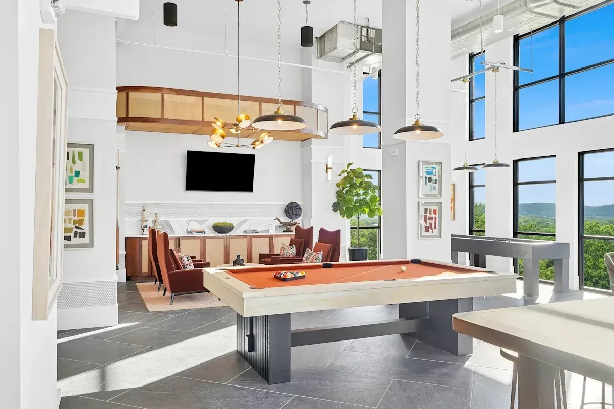 Luxurious resident lounge with pool table, shuffleboard, and seating areas.