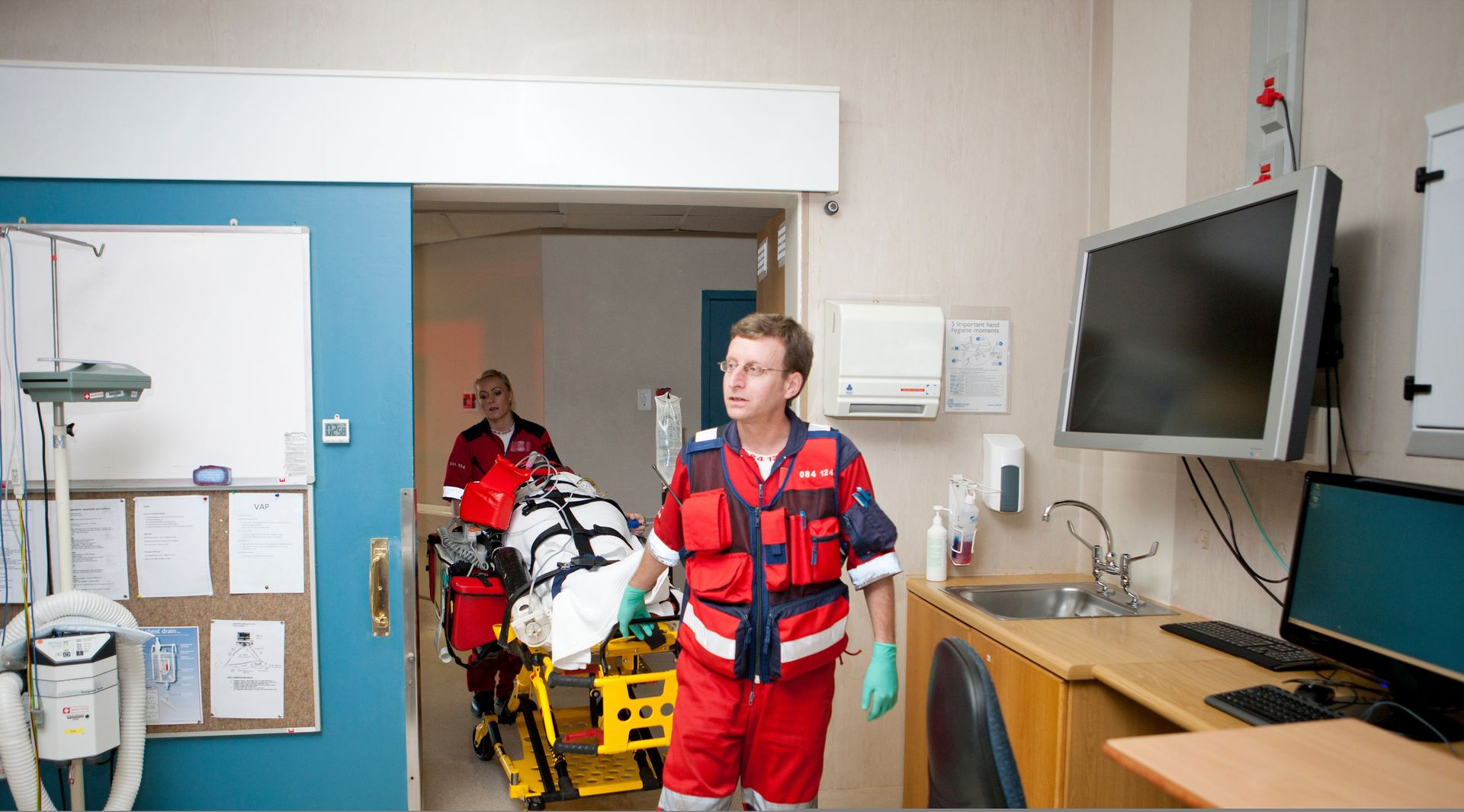 Male paramedic in uniform pushing patient on a corridor to emergency room. Male paramedic in uniform pushing patient on a corridor to emergency room.