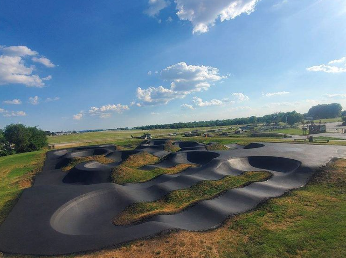 An aerial view of a bike park with a blue sky and clouds in the background.