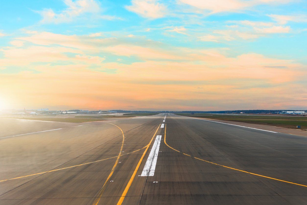An aerial view of an airport runway at sunset.
