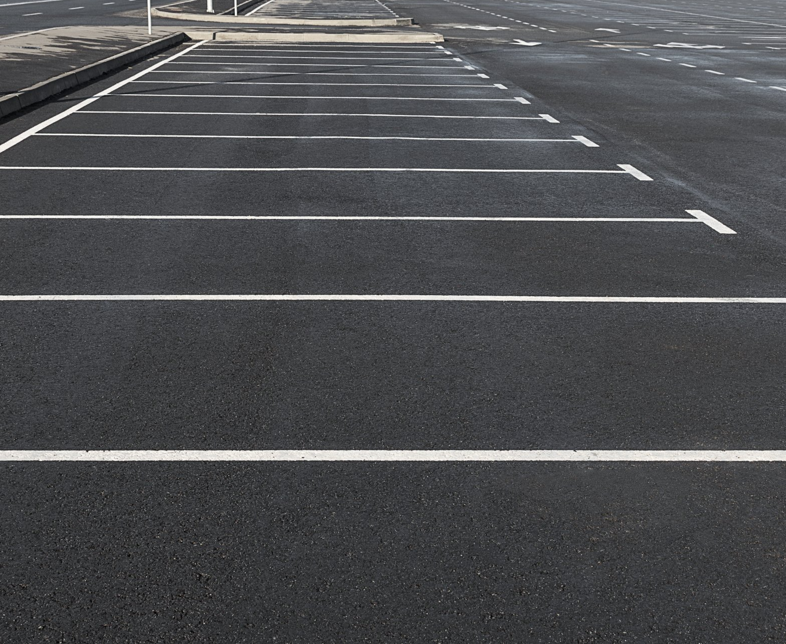 A row of parking spaces with white arrows on them